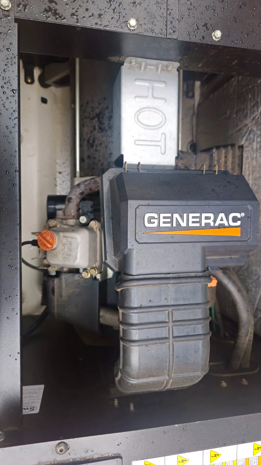 Air-cooled Generac engine inside a home standby generator, with HOT cast into the exhaust cover