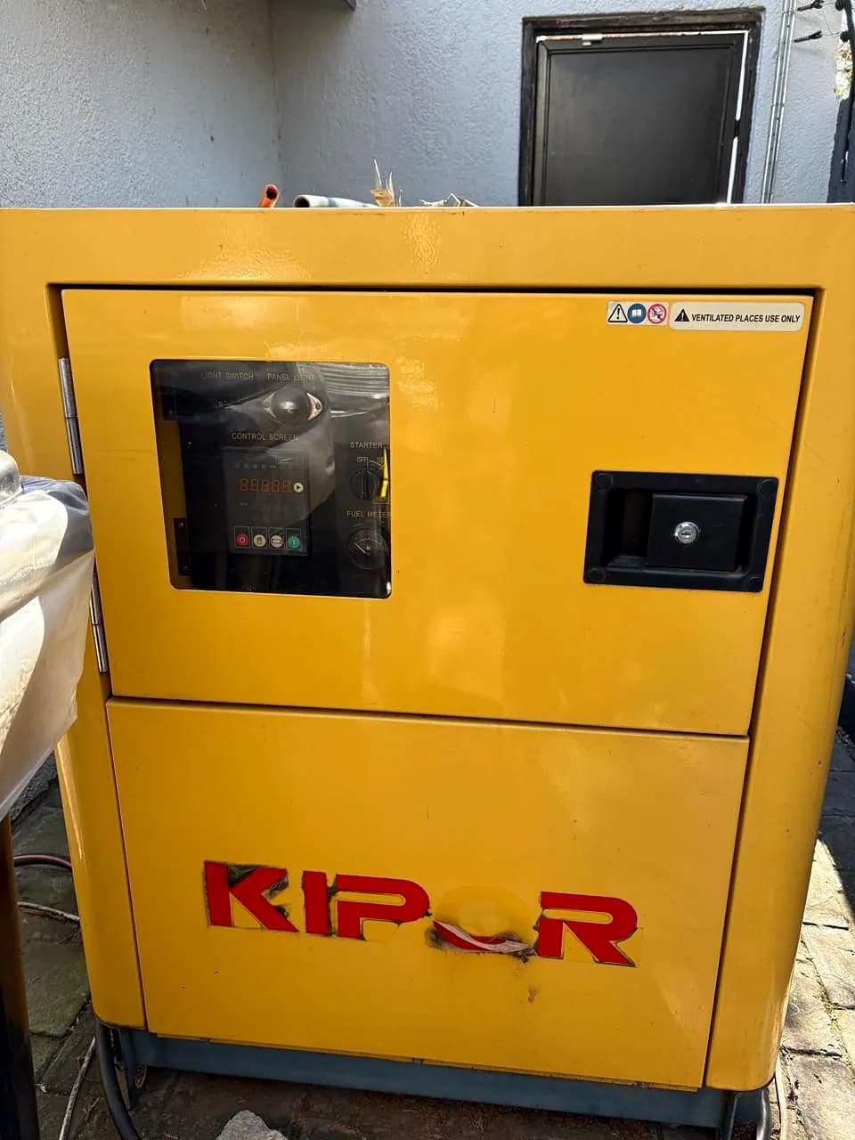 Yellow Kipor silent diesel generator with its controller window and door latch